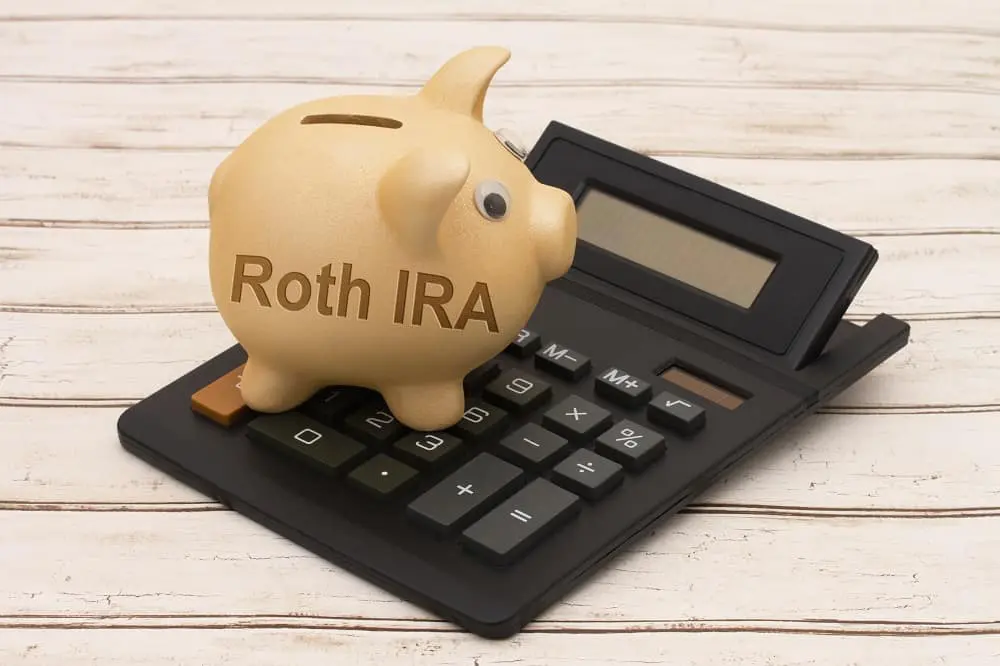 Roth IRA piggy bank on top of calculator